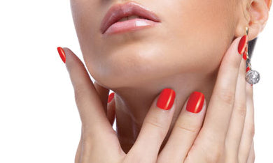 Close-up of a woman's lower face, neck, and hands with bright red manicured nails, wearing a dangling silver earring against a white background.